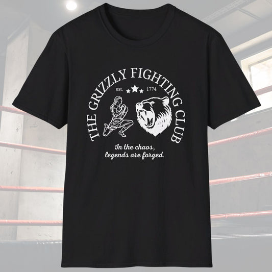 Black shirt with a white design. The design has the words The Grizzly Fighting Club and has a Muay Thai guy doing the Wai Khru next to a Grizzly bear. At the bottom of the design has the words In the Chaos, legends are forged.