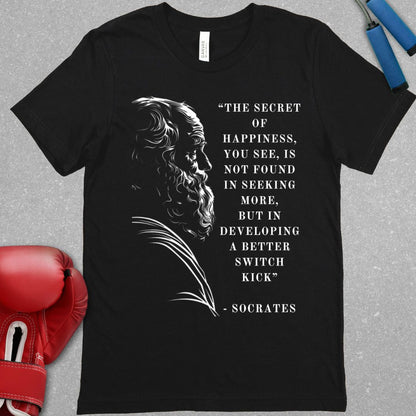 Black shirt with a picture of Socrates and next to him text that says The secret of happiness, you see, is not found in seeking more, but in developing a better switch kick.