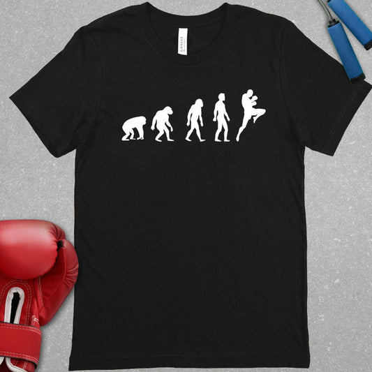 Black shirt with a graphic design showing the evolution of humans from apes and then the final evolution is a muay thai fighter throwing a knee