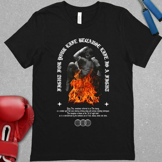 Black shirt with a design that has a picture of a Muay Boran fighter with fire around him and the phrase Fight for your life cause life is a fight is on the shirt. Also a short description of the definition of Thai boxing is on the shirt.