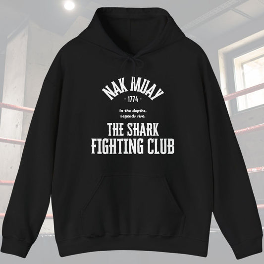 Black hoodie with typography design. Has the words Nak Muay at top of design with the following phrase in the middle In the depths, Legends rise. Also has the words The Shark Fighting Club at the bottom of the design.