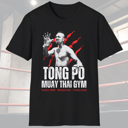 Black shirt with a picture of Tong Po and the design has the words Tong Po Muay Thai gym – Since 1989, Bangkok, Thailand. 