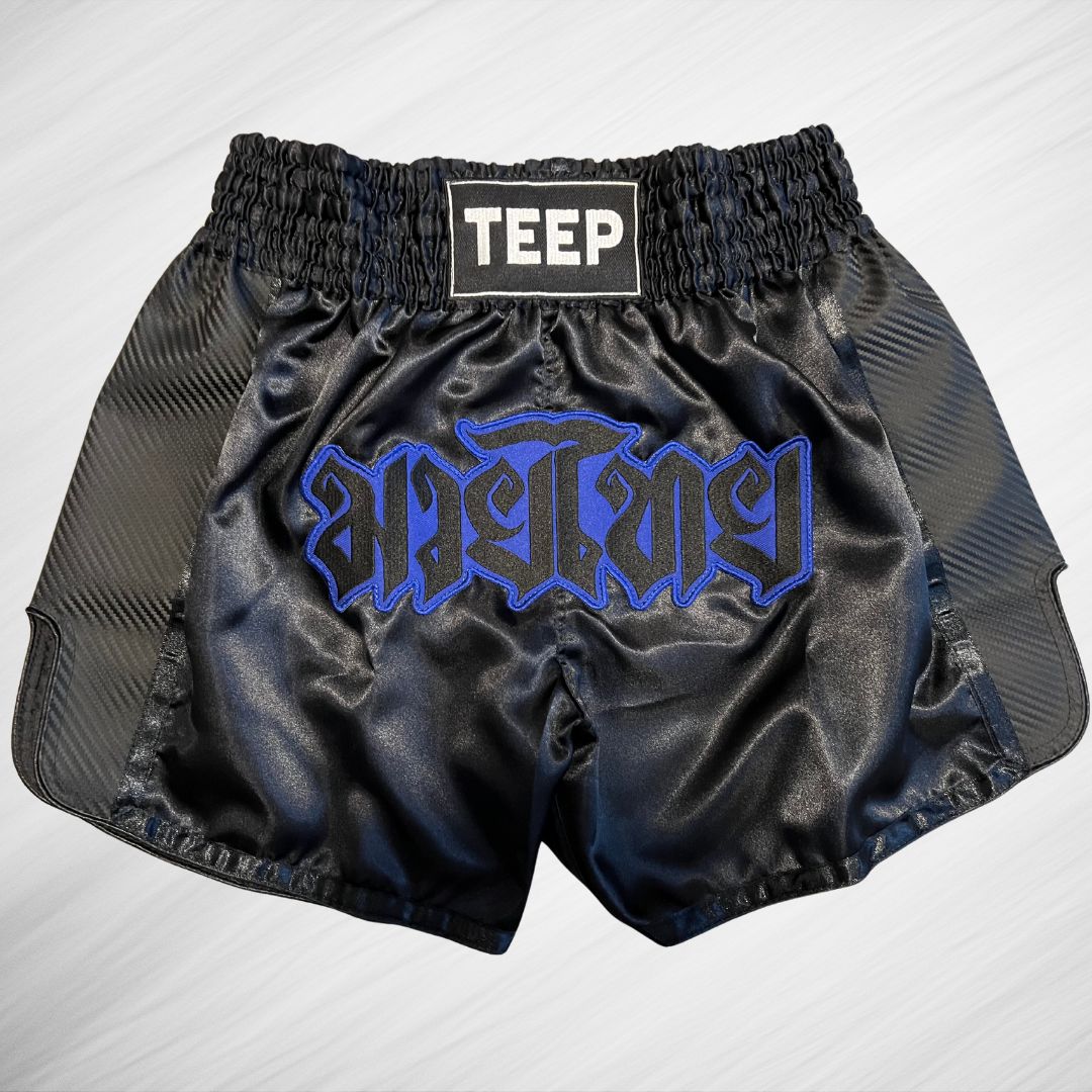 Black Muay Thai shorts with the word Teep on the waistband and Muay Thai in Thai writing on the front